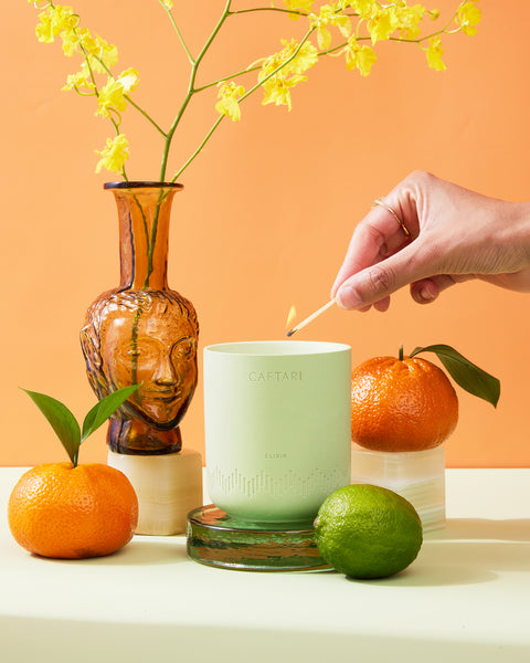Elixir essential oil candle citrus scent for energy styled photo