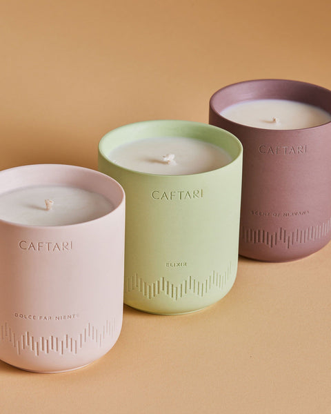 Three Caftari candles in signature pink, green, and mauve vessels