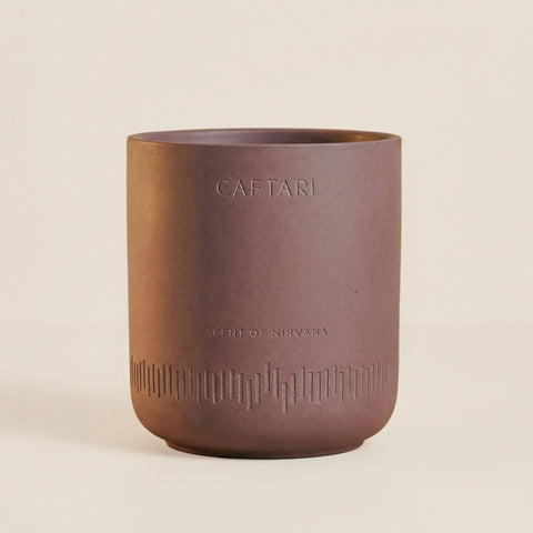Caftari Scent of Nirvana non-toxic candle in a mauve ceramic vessel